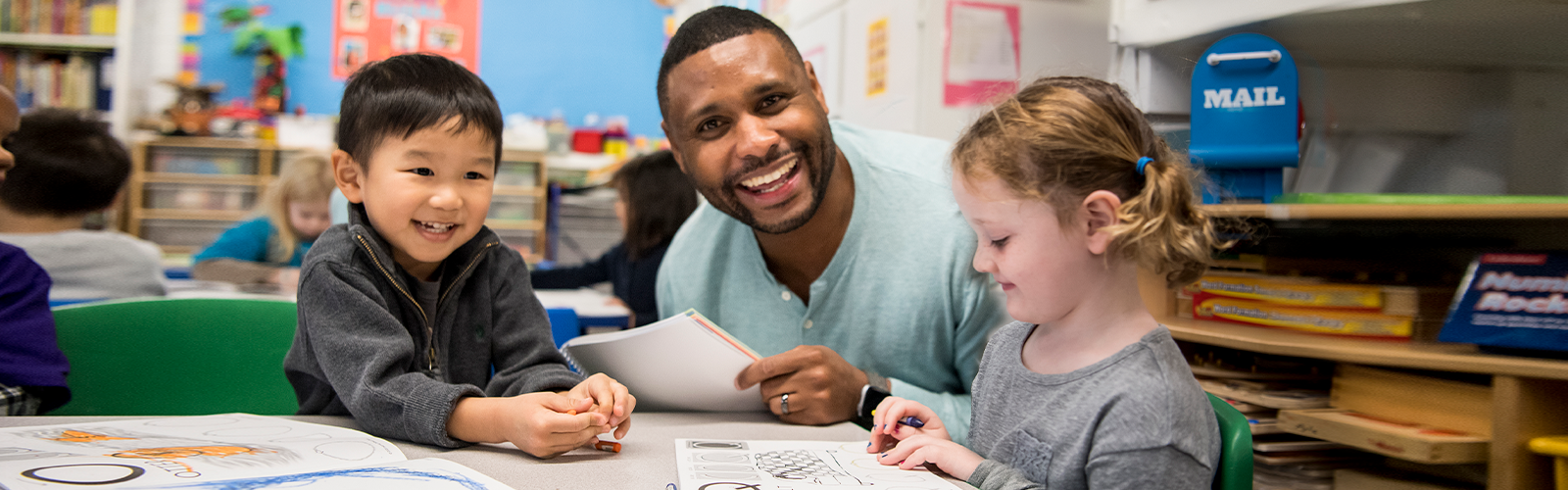 Teacher with students learning with worksheets