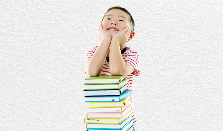 Delighted student leaning on a stack of books