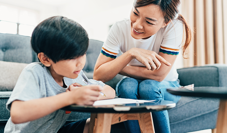 Parent and child working on handwriting assignment together