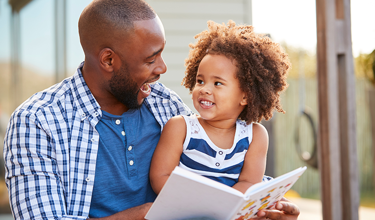 Parent and child joyfully reading a book together