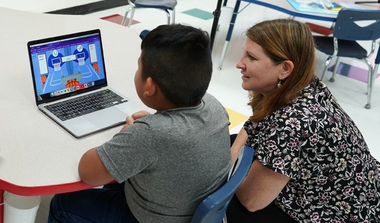 Teacher with student learning on laptop