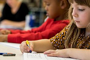 Student practicing handwriting with structured writing curriculum materials – early education writing instruction in classroom setting