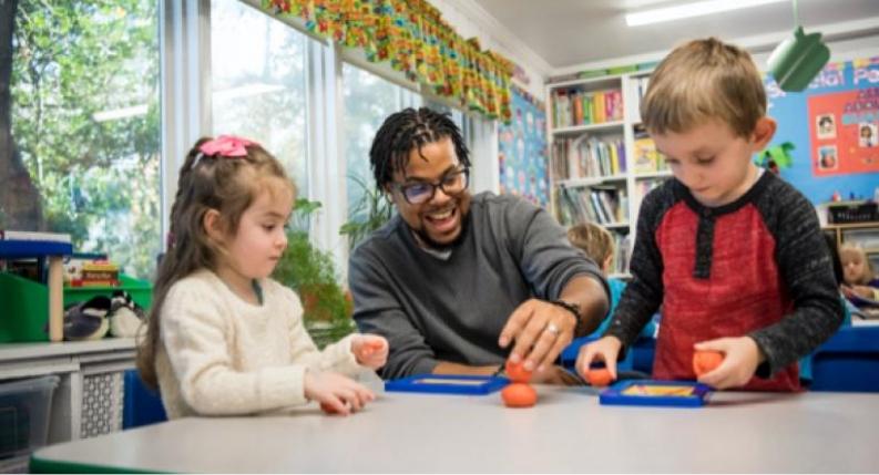 Teacher guiding children through letter formation with Roll-A-Dough