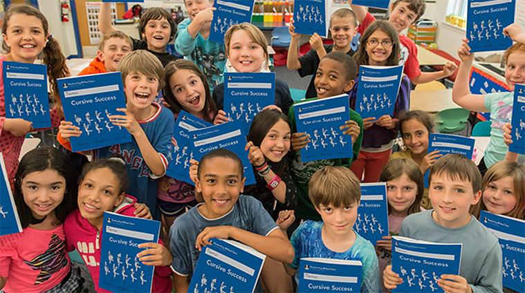 Students holding Cursive Success workbooks